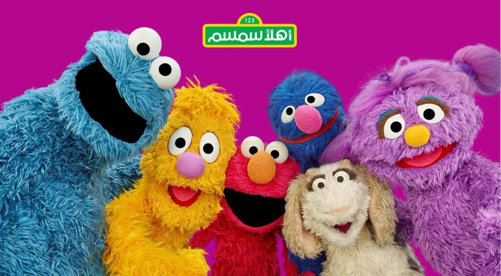 Sesame Street-Ahlan Simsim muppets in order line-up: Blue monster Kaki, yellow Jad, red Elmo, tall blue Gargur, baby goat Ma’zooza, purple Basma